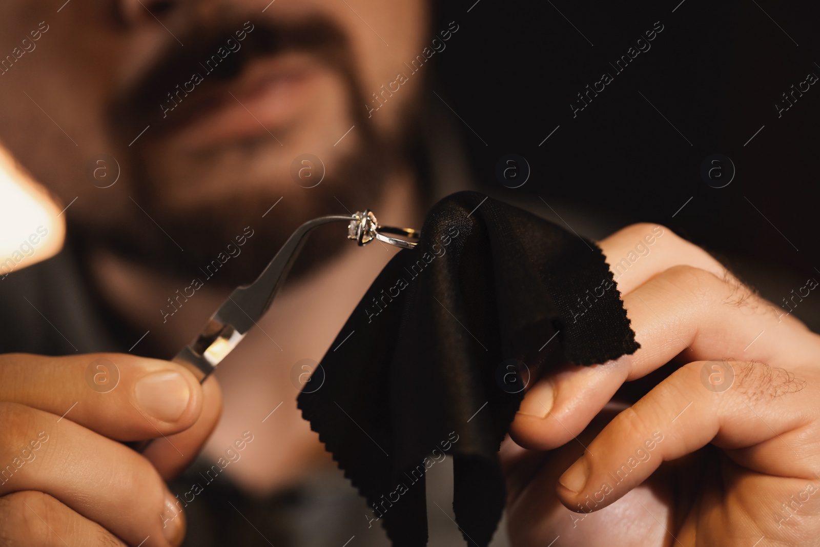 Photo of Jeweler working with ring on blurred background, closeup