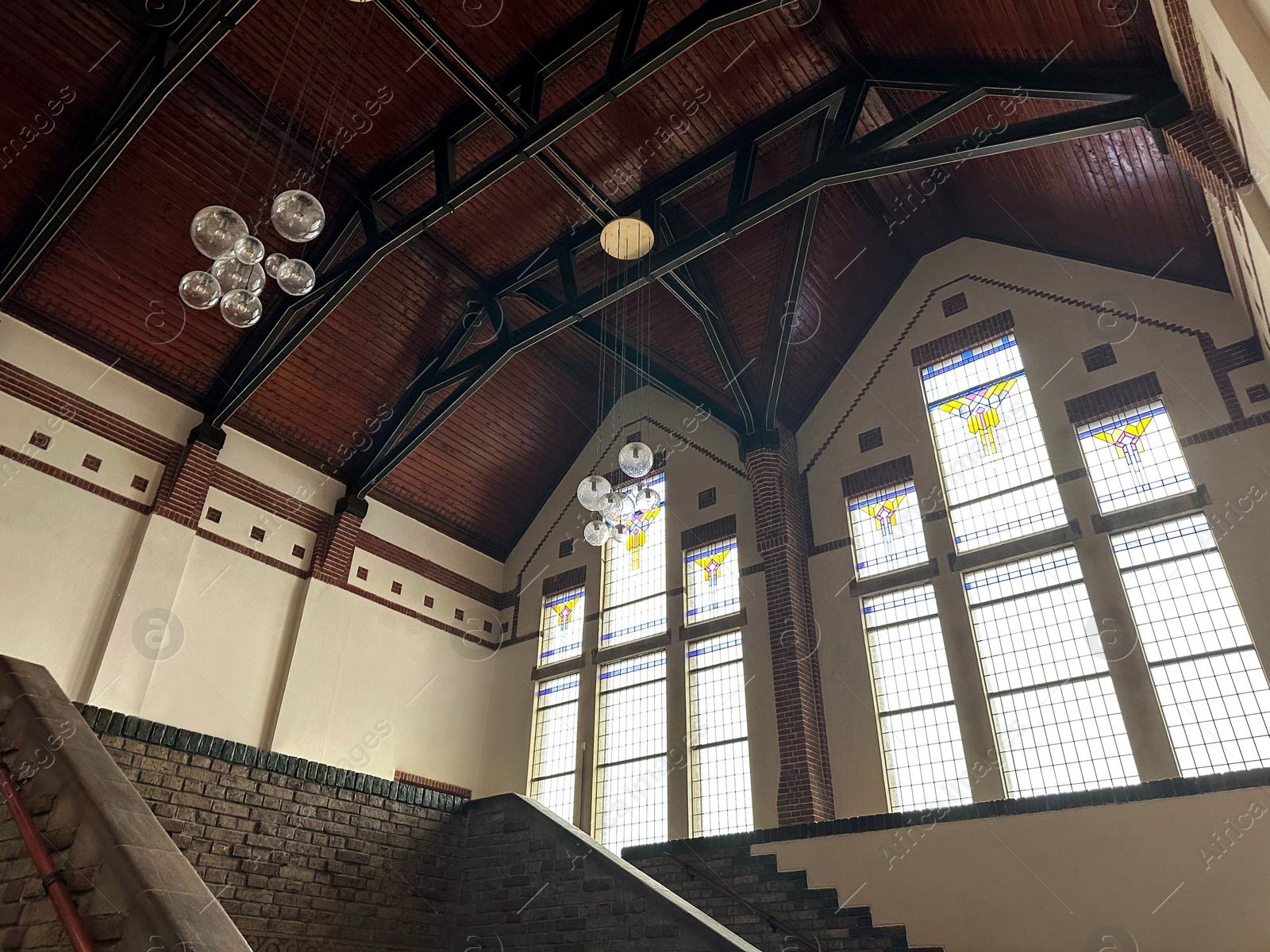 Photo of Lyceum hall with beautiful stained glass windows and modern lamps