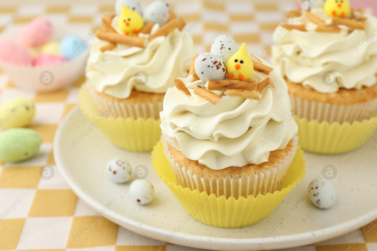 Photo of Tasty Easter cupcakes with vanilla cream on table, closeup