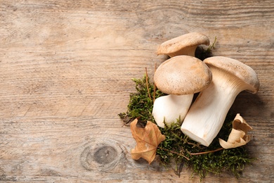 Photo of Fresh wild mushrooms on wooden background, top view. Space for text