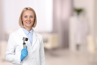 Professional dermatologist with dermatoscope on blurred background, space for text