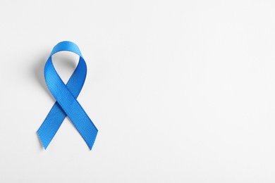 Photo of Blue ribbon on white background, top view. Cancer awareness