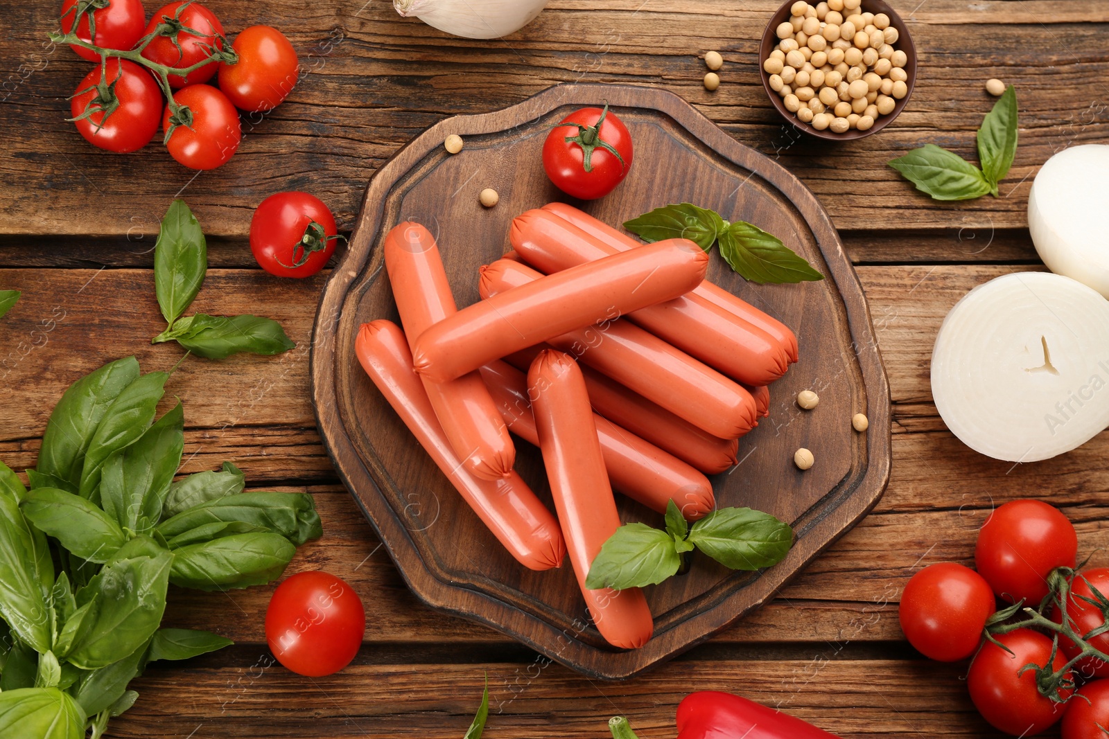 Photo of Fresh raw vegetarian sausages, soybeans and vegetable on wooden table, flat lay