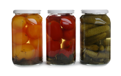 Photo of Glass jars of different pickled vegetables isolated on white