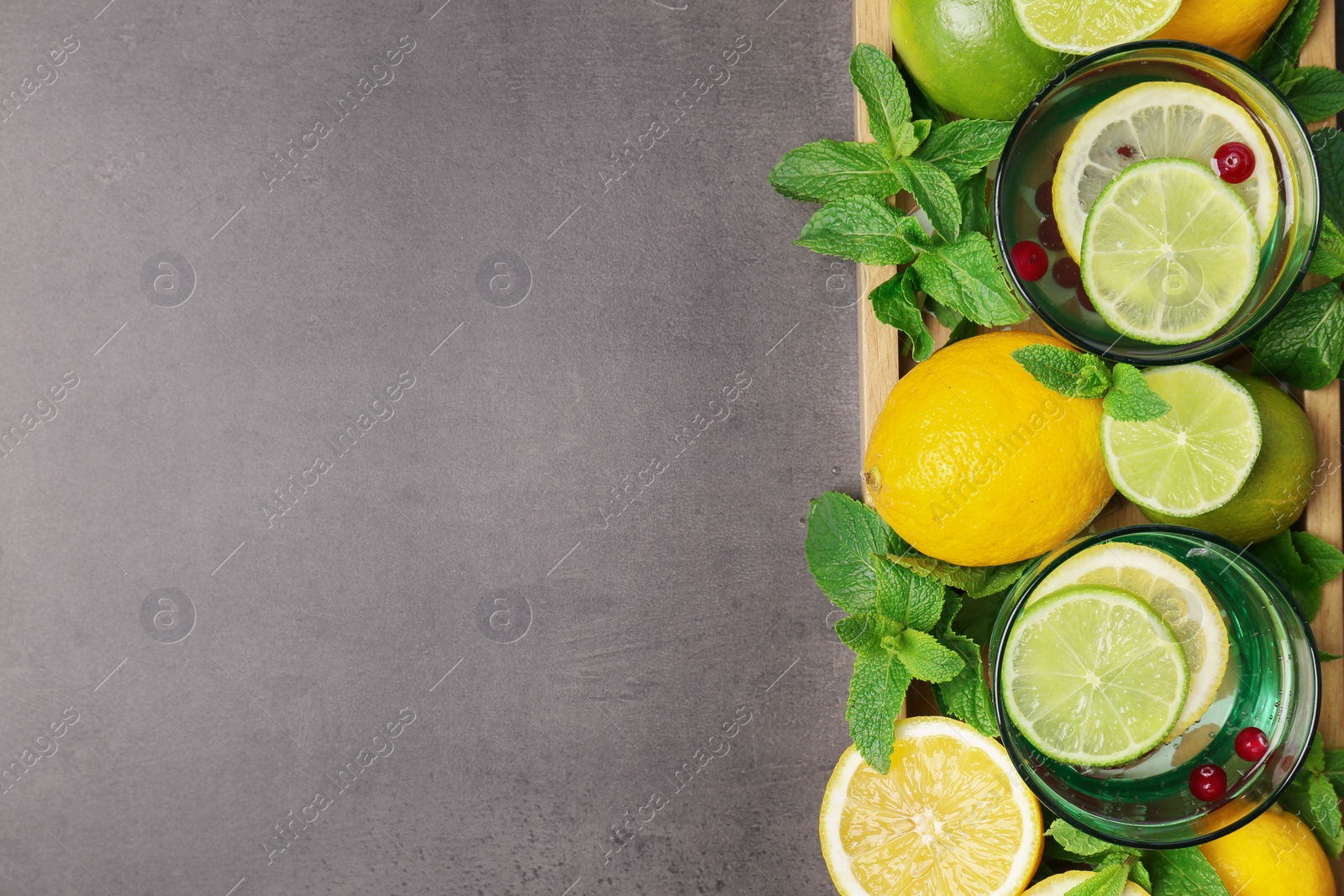 Photo of Flat lay composition with detox lemonade and ingredients on grey background