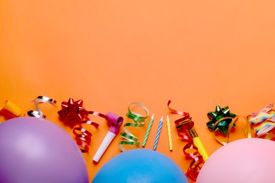 Photo of Flat lay composition with accessories for birthday party on orange background. Space for text