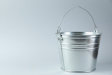 Photo of One shiny metal bucket on white background. Space for text