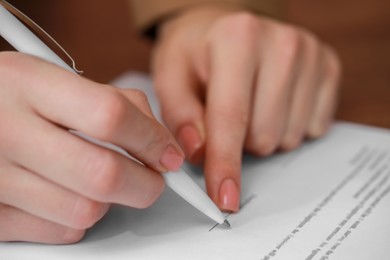 Photo of Woman signing documents on brown background, closeup