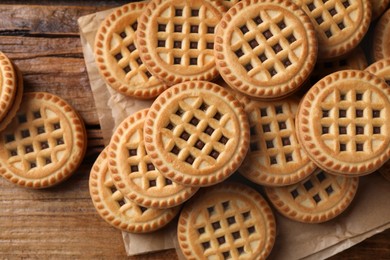 Tasty sandwich cookies with cream on wooden table, flat lay