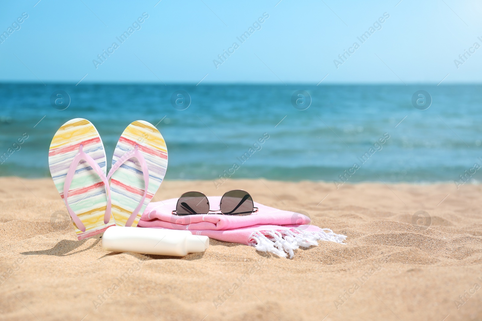 Photo of Set of different beach objects on sand near sea. Space for text