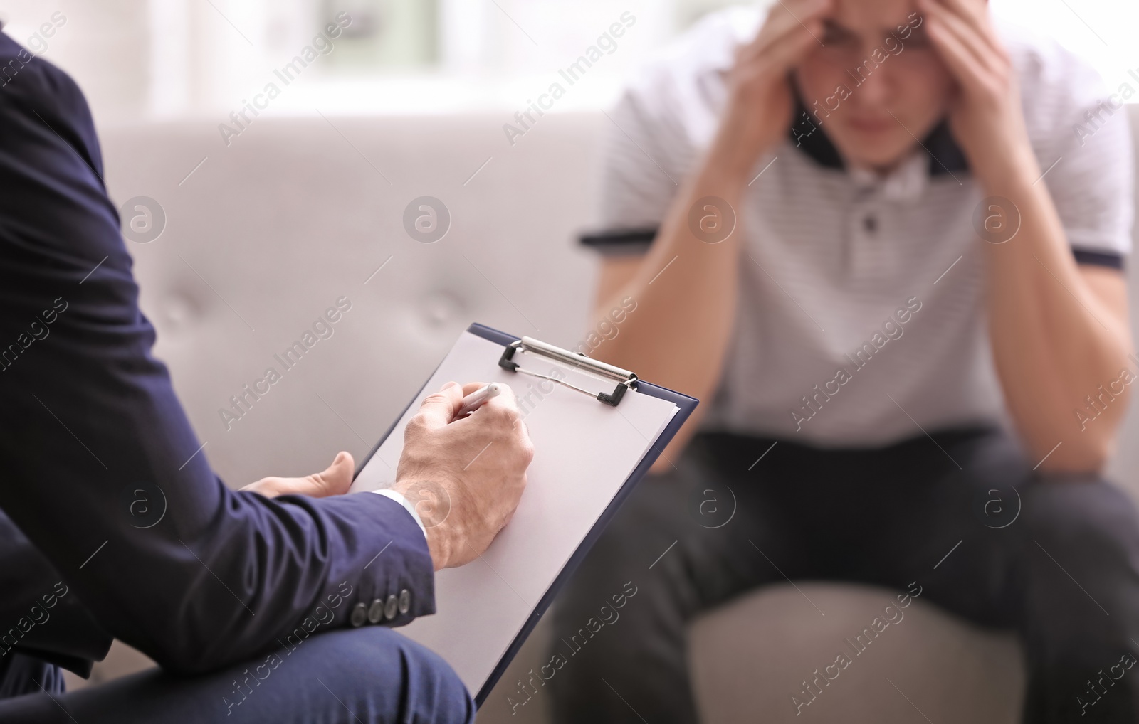 Photo of Psychotherapist working with young man in office, closeup