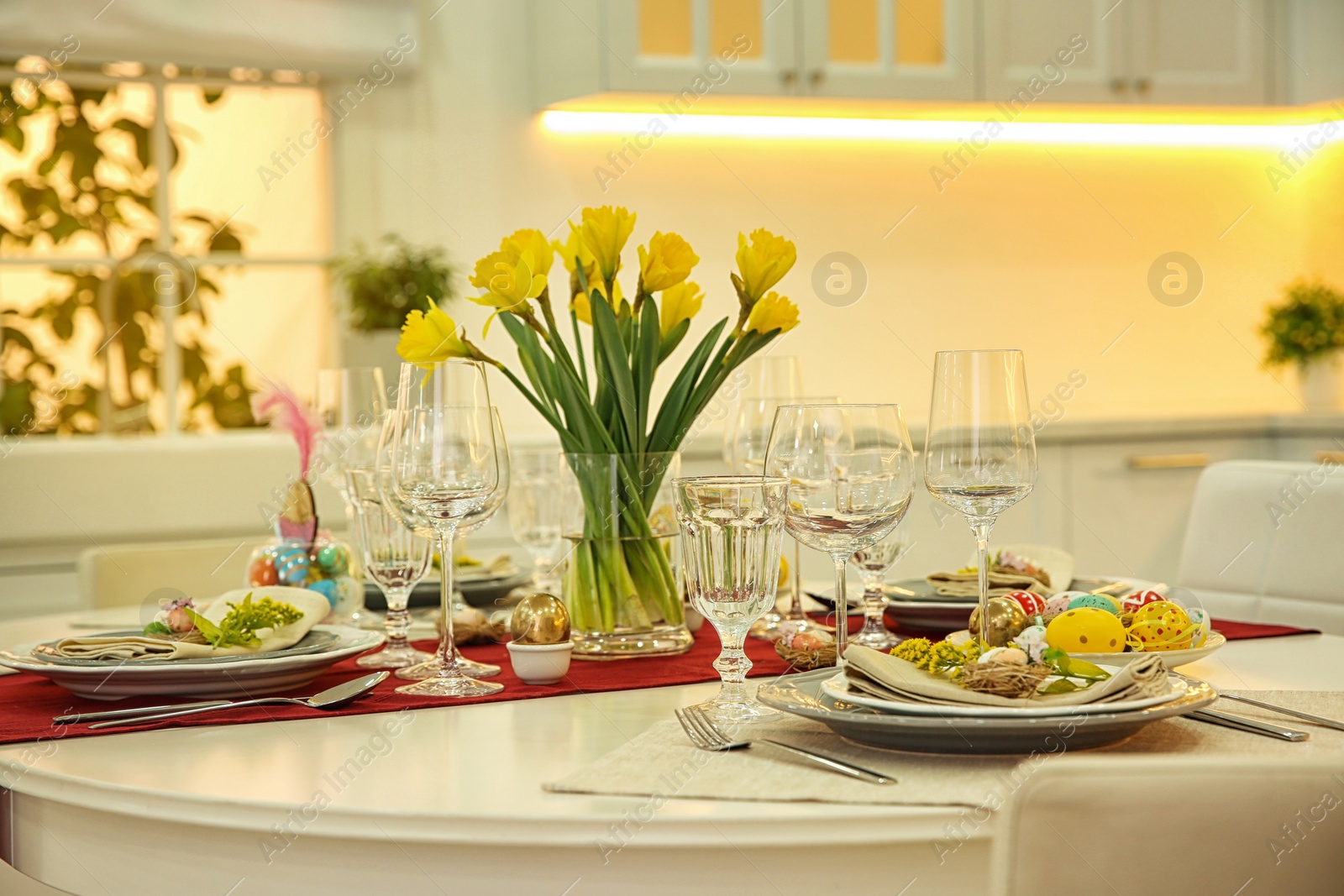 Photo of Festive Easter table setting with floral decor in kitchen