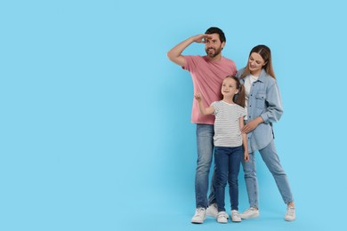 Photo of Happy family on light blue background, space for text