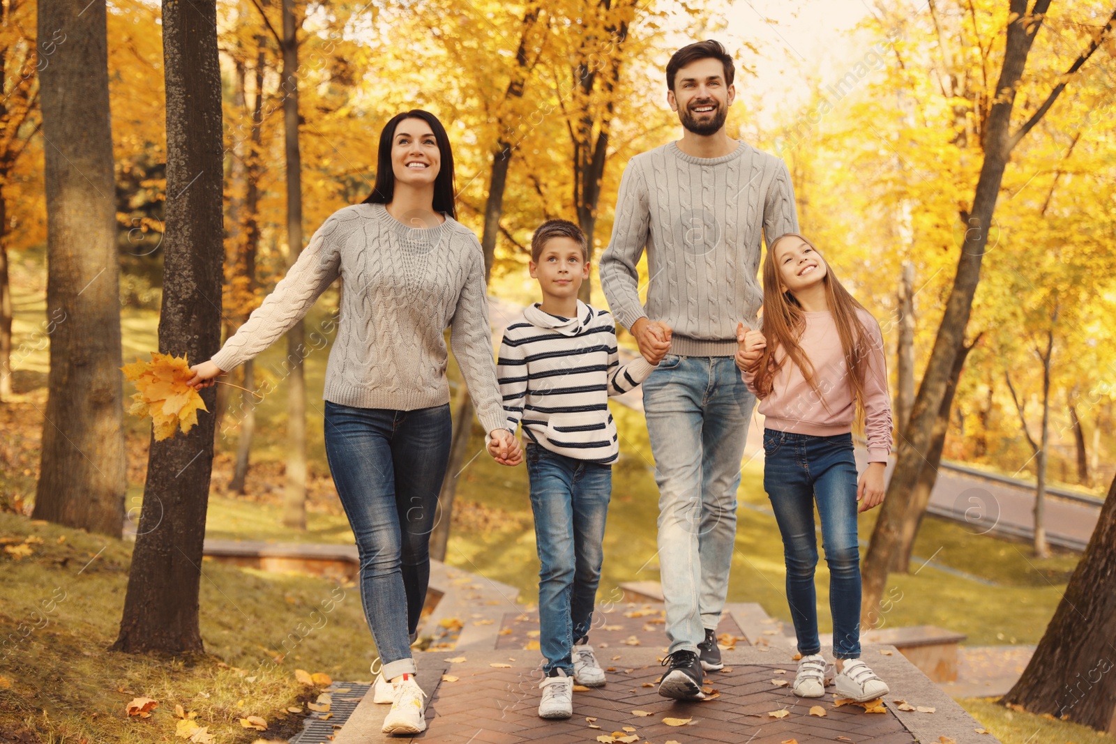 Photo of Happy family with children walking in autumn park