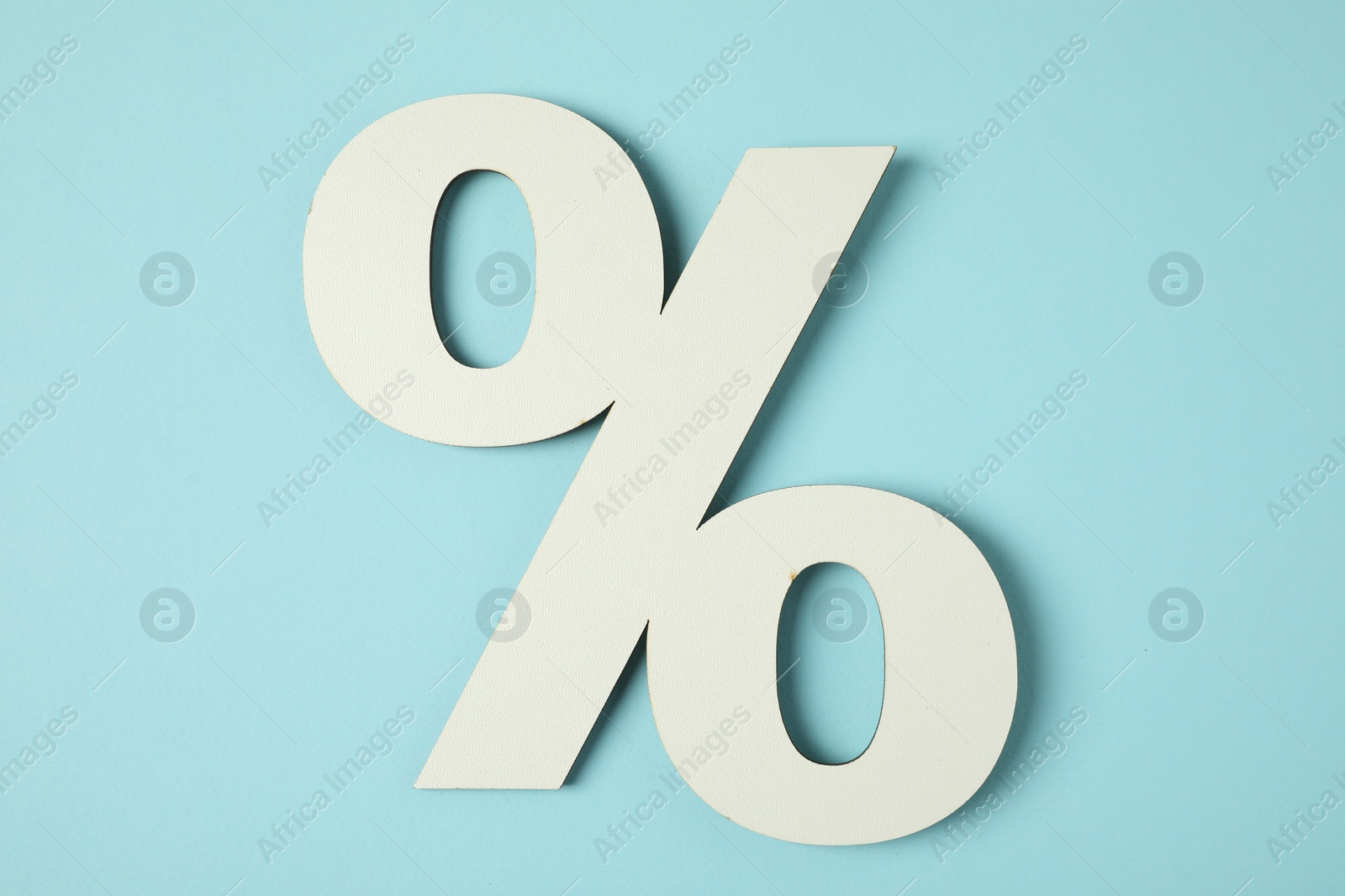 Photo of White percent sign on light blue background, top view