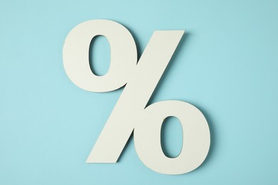 Photo of White percent sign on light blue background, top view