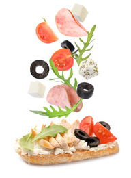 Image of Tasty bruschetta with flying ingredients on white background