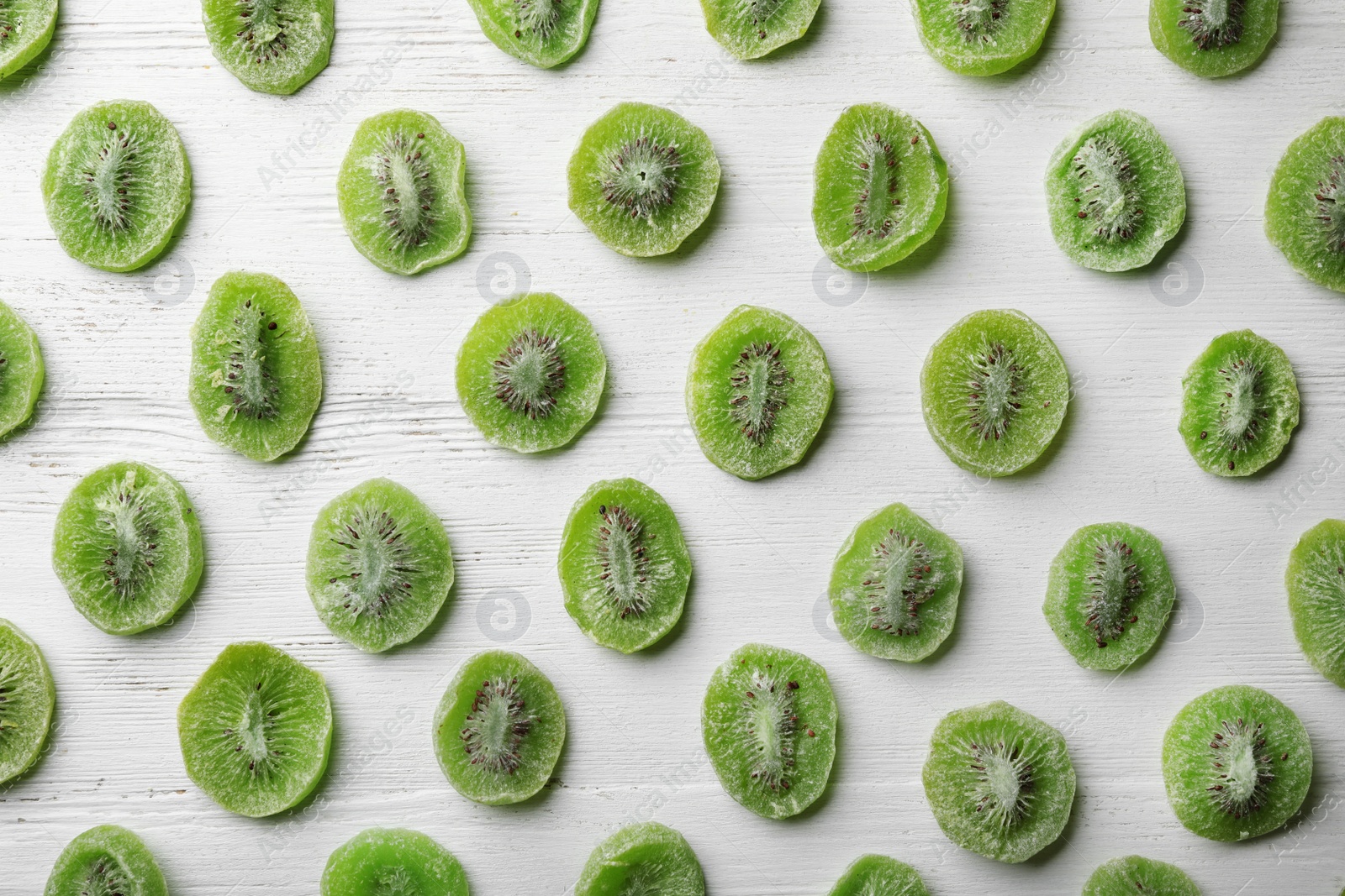 Photo of Slices of kiwi on wooden background, flat lay. Dried fruit as healthy food