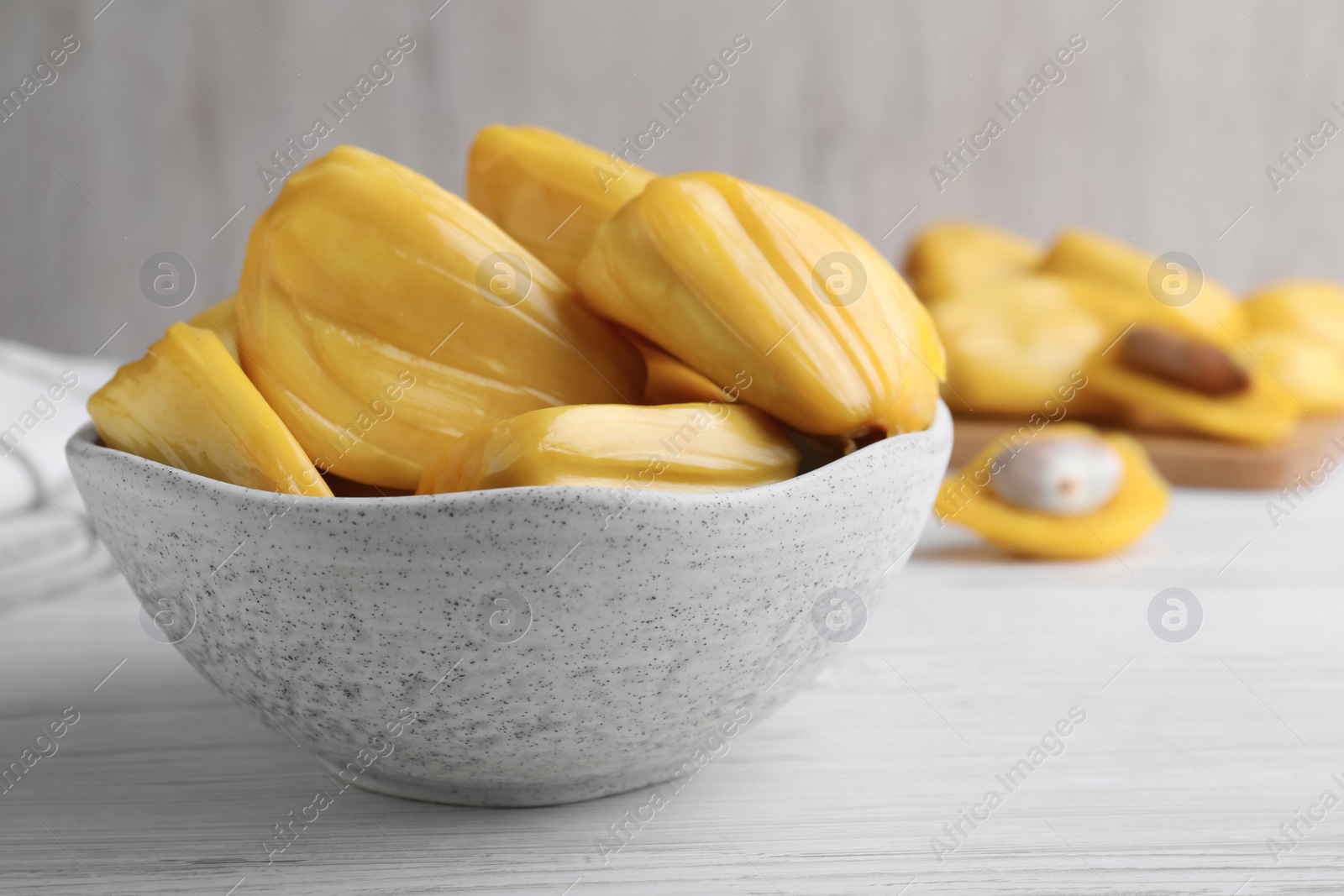 Photo of Delicious exotic jackfruit bulbs on white wooden table