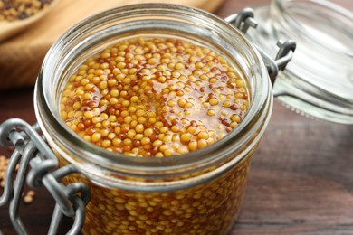 Photo of Whole grain mustard in jar on table, closeup