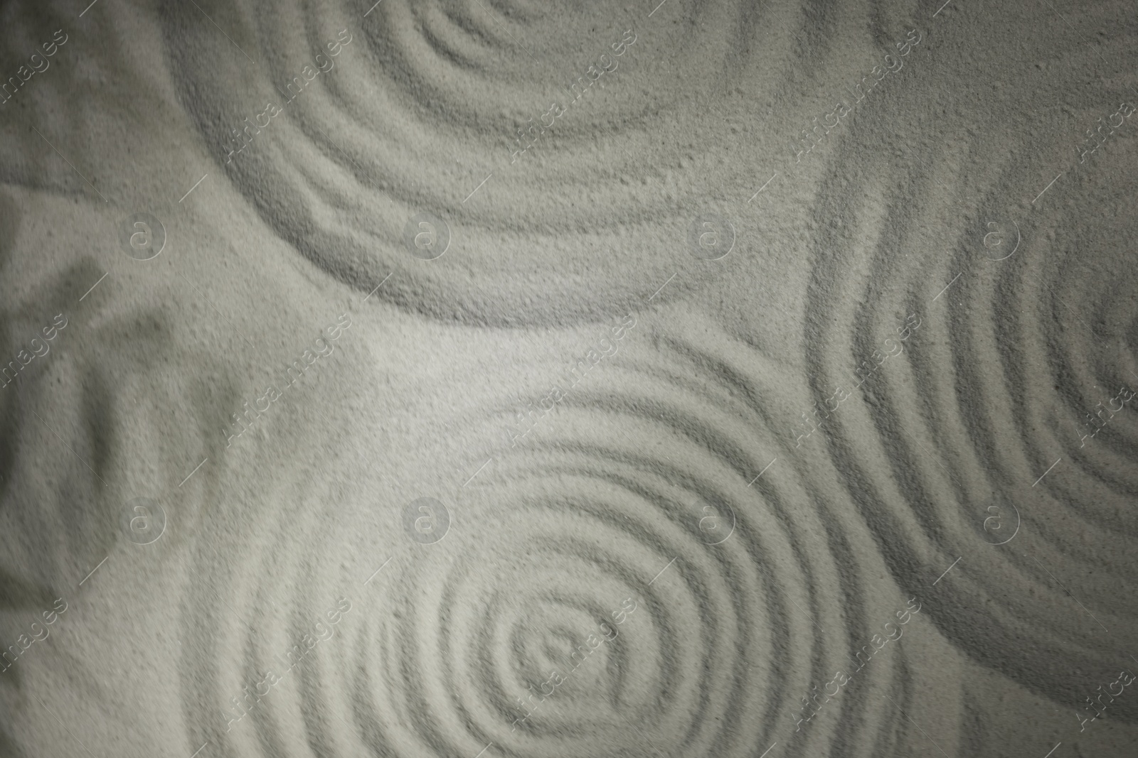 Photo of Beautiful spirals and shadows of leaves on sand, top view. Zen garden