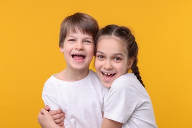 Photo of Happy brother and sister on orange background