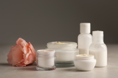 Photo of Jars with cream and bottles on light table. Hand care cosmetics