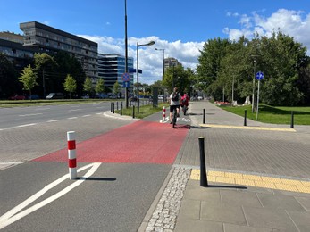 Photo of Cyclists riding bicycles on lane in city