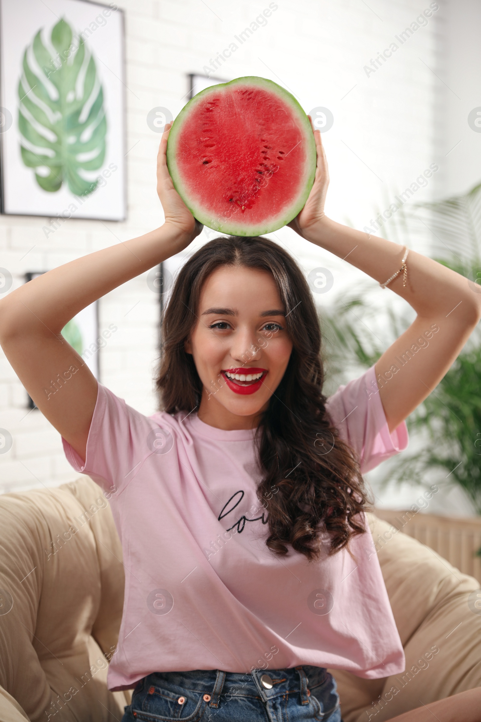 Photo of Beautiful young woman with watermelon at home