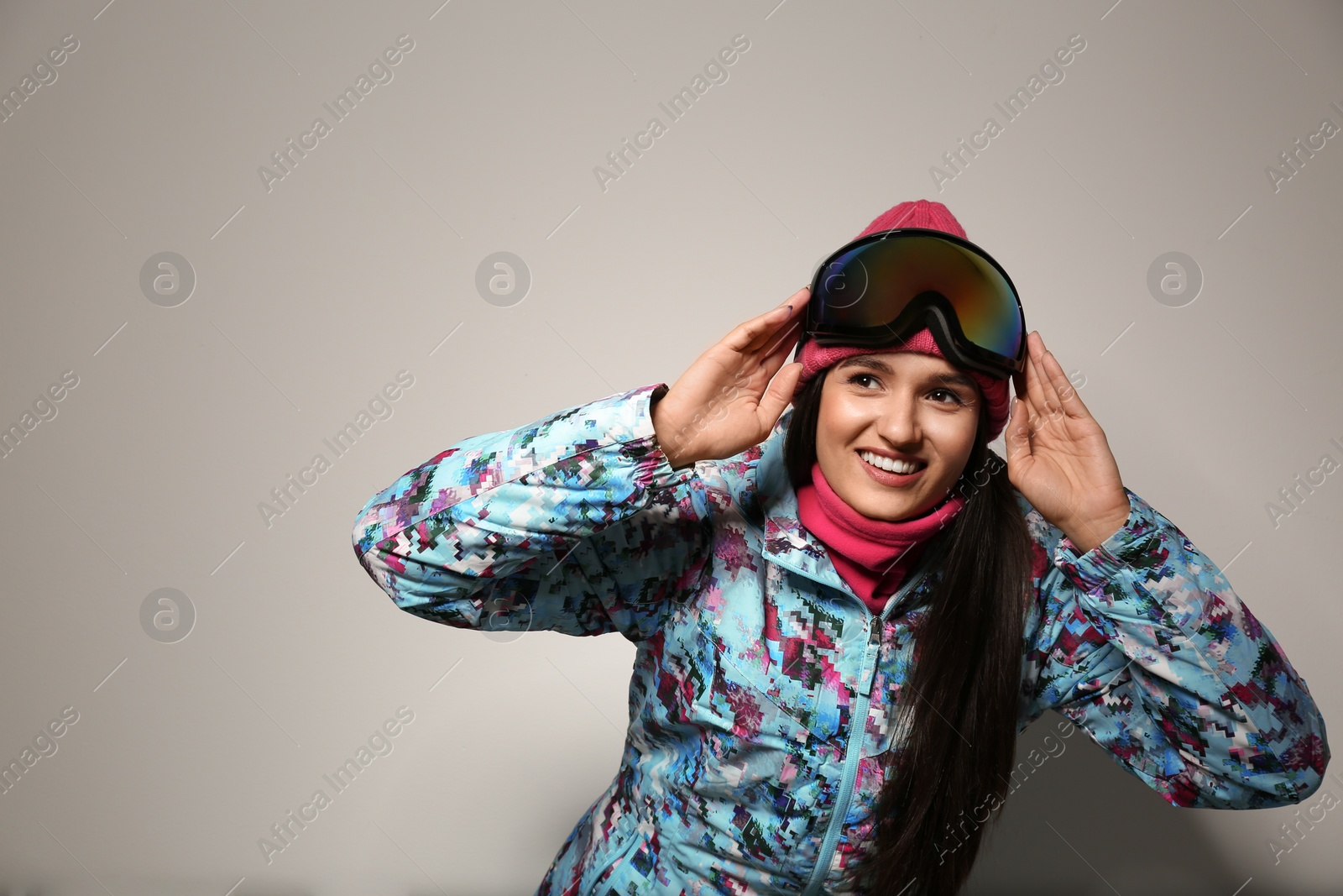 Photo of Woman wearing stylish winter sport clothes on light grey background