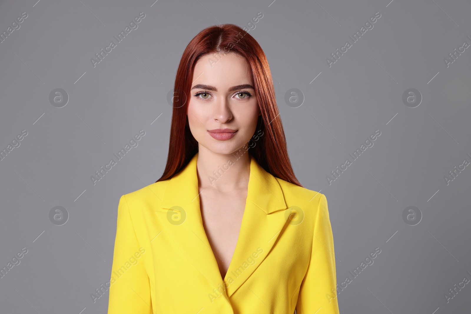 Photo of Beautiful woman with red dyed hair on light gray background