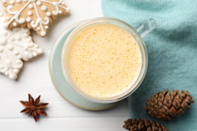 Tasty eggnog, cookies and anise star on white wooden table, flat lay