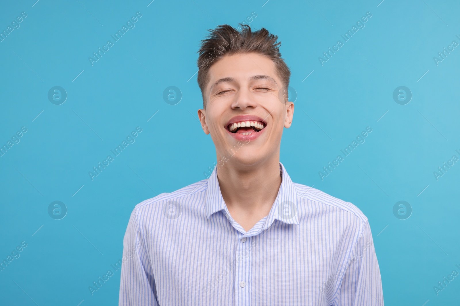 Photo of Young man laughing on light blue background