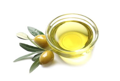 Little bowl with oil, ripe olives and leaves on white background