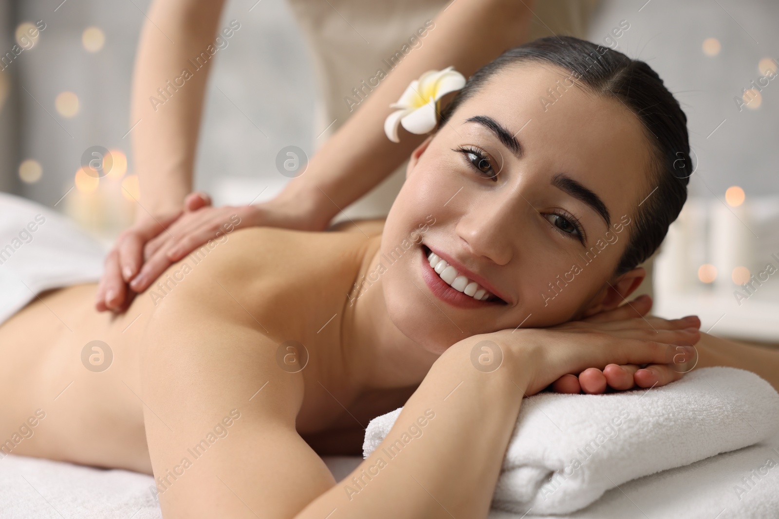 Photo of Woman receiving back massage on couch in spa salon