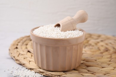 Tapioca pearls and scoop in bowl on wicker mat