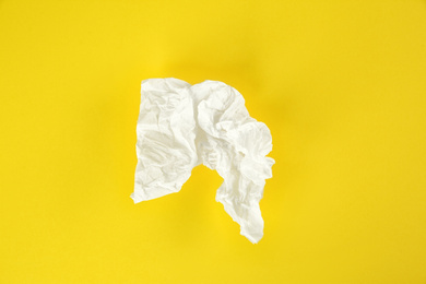 Photo of Used paper tissue on yellow background, top view