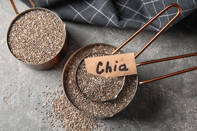 Photo of Saucepans with chia seeds on grey background, flat lay