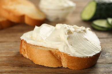 Delicious sandwich with cream cheese on wooden table, closeup