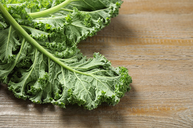 Fresh green kale leaves on wooden table, closeup