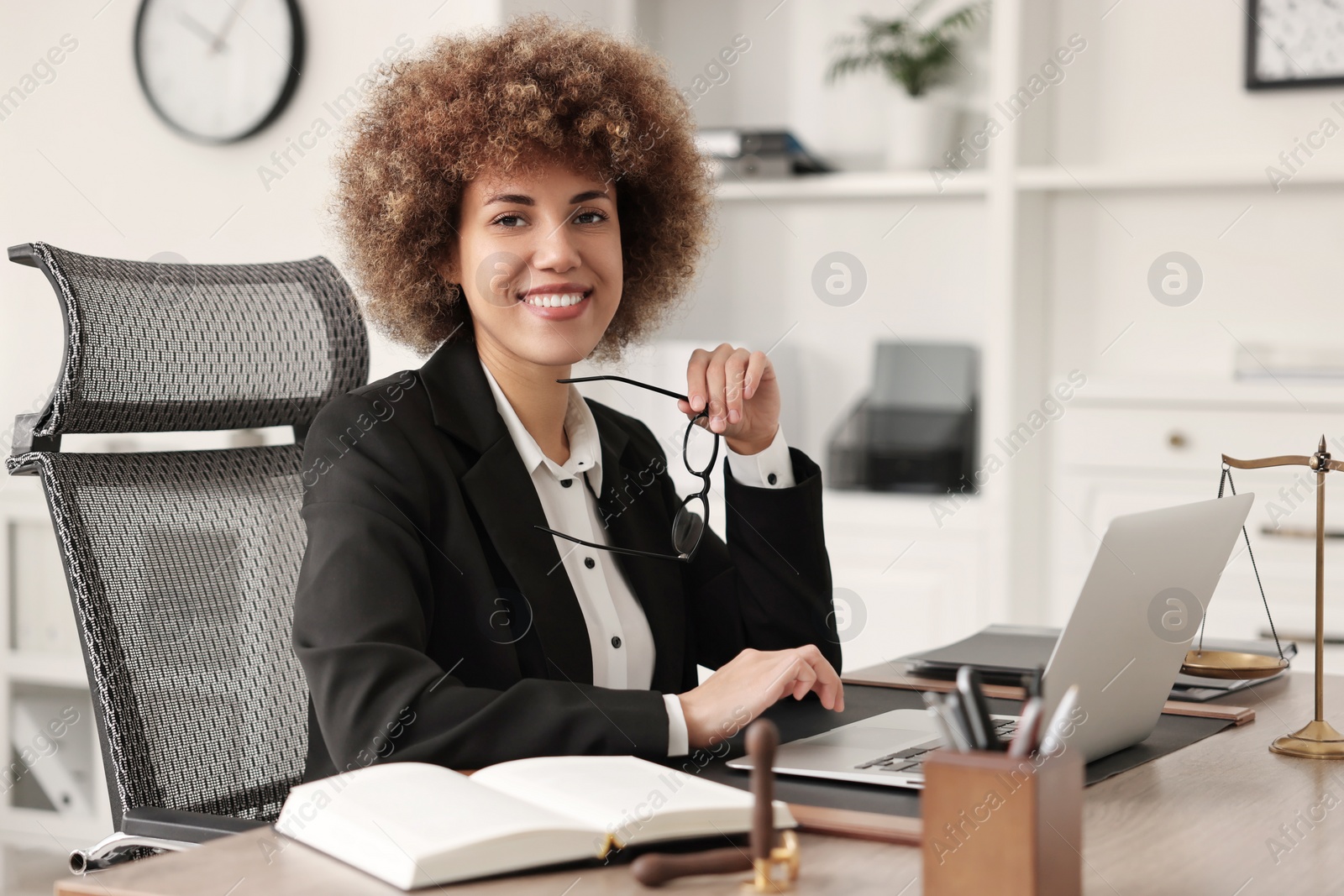 Photo of Notary with glasses using laptop at workplace in office