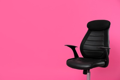 Comfortable office chair on pink background, space for text