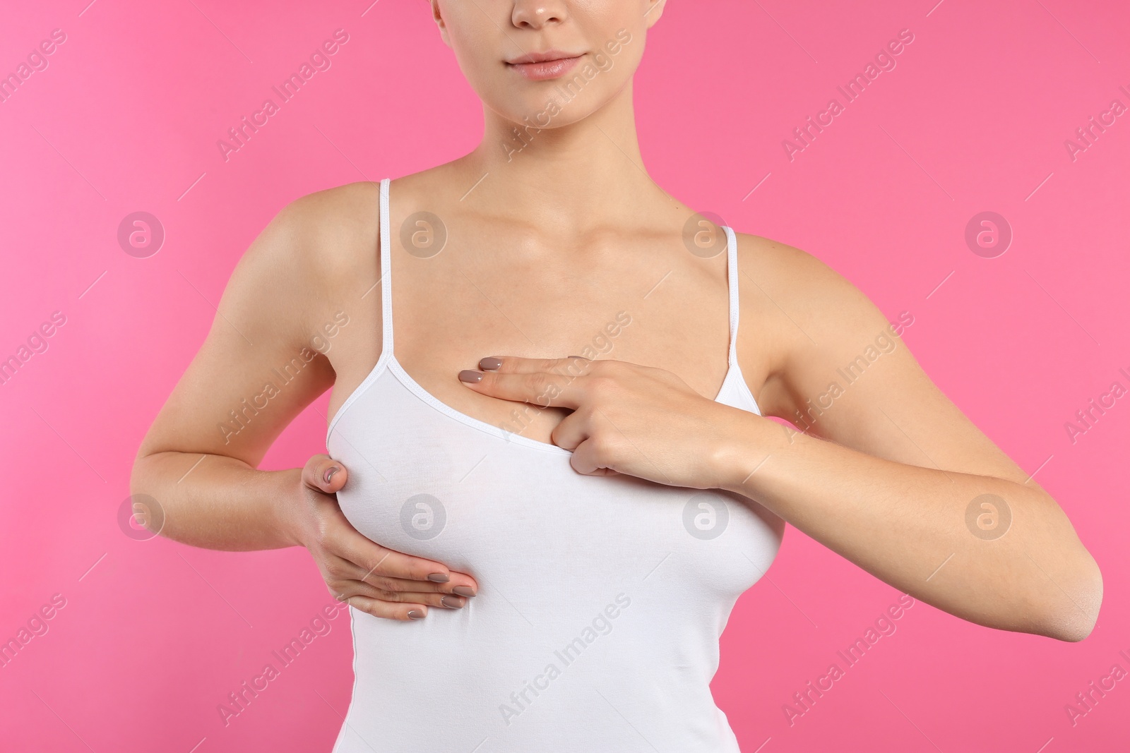 Photo of Woman checking her breast on color background, closeup