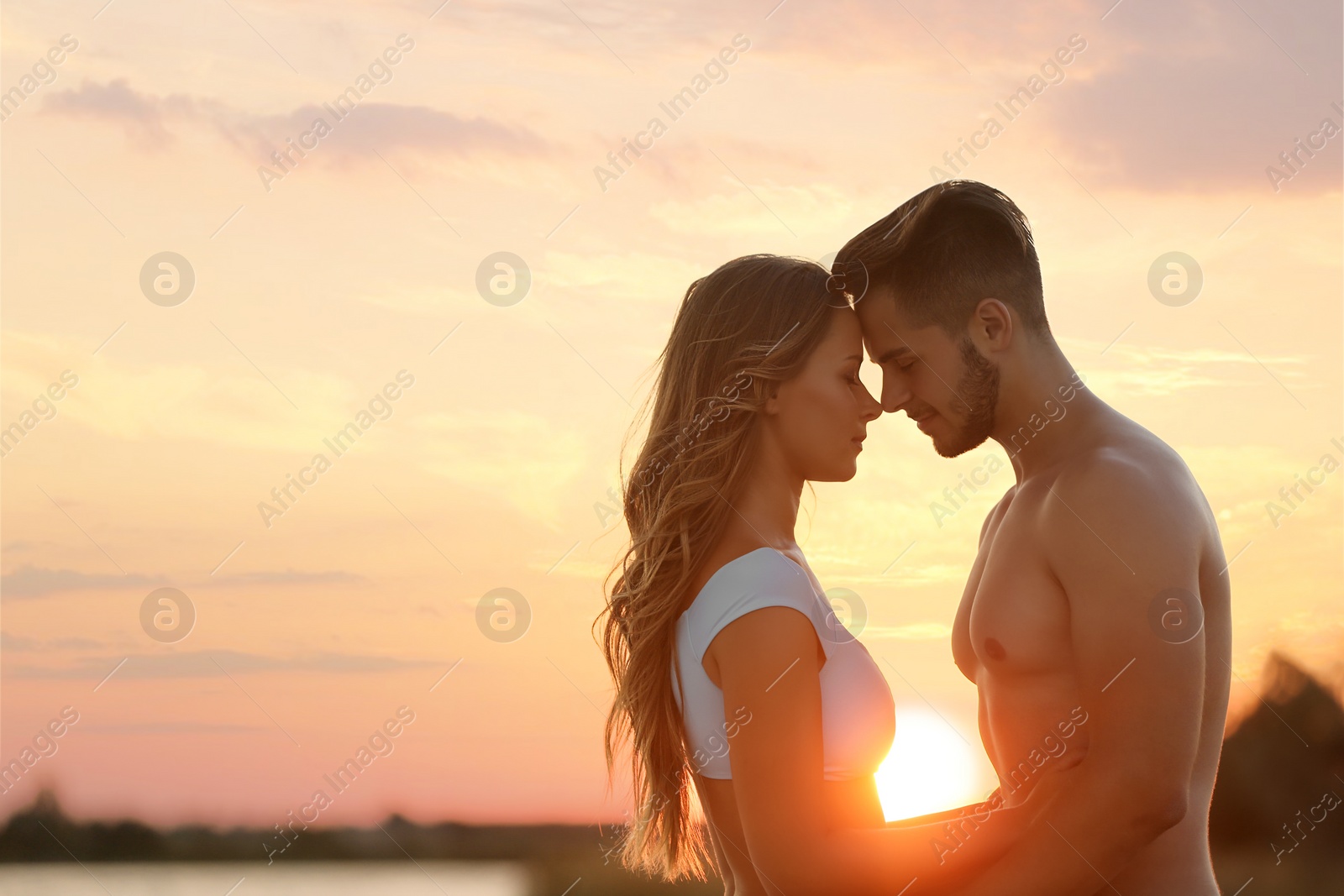 Photo of Happy young couple in beachwear outdoors at sunset