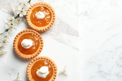 Photo of Tasty tartlets with jam on light background, top view