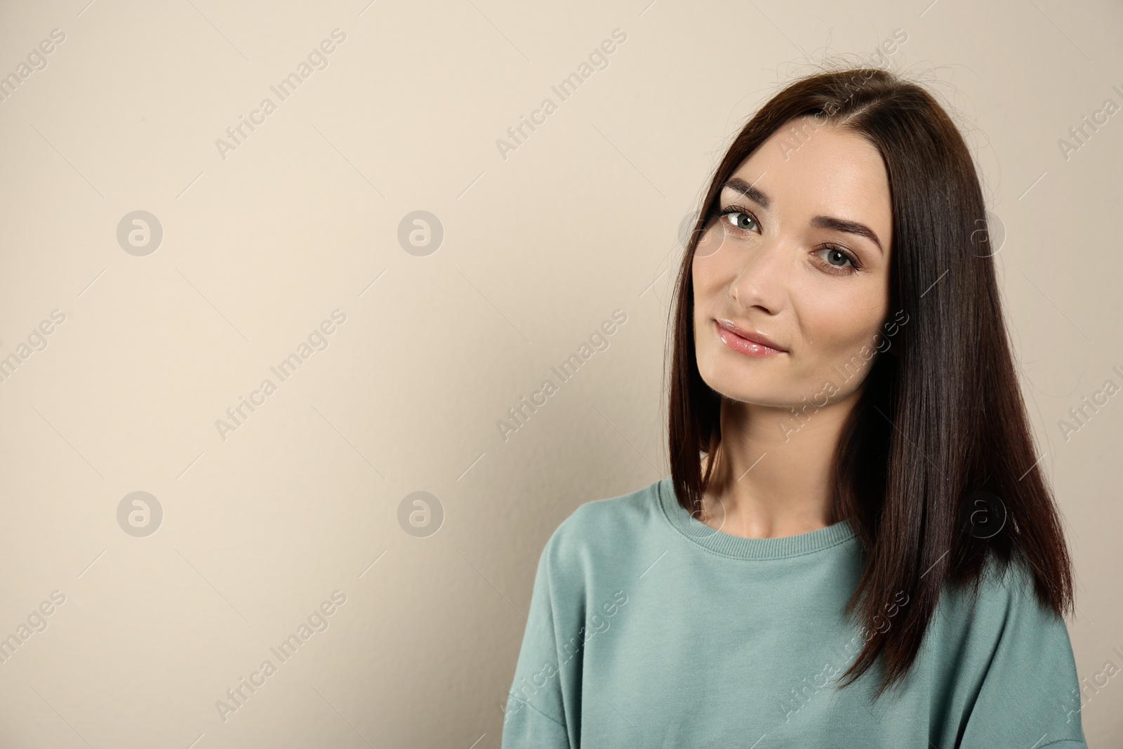 Photo of Portrait of pretty young woman with gorgeous chestnut hair on light background, space for text