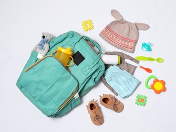 Photo of Composition with maternity backpack and baby accessories on white background, top view