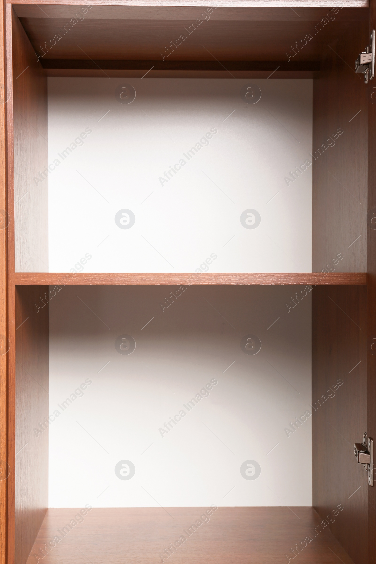 Photo of Open wooden wardrobe with empty shelves, closeup