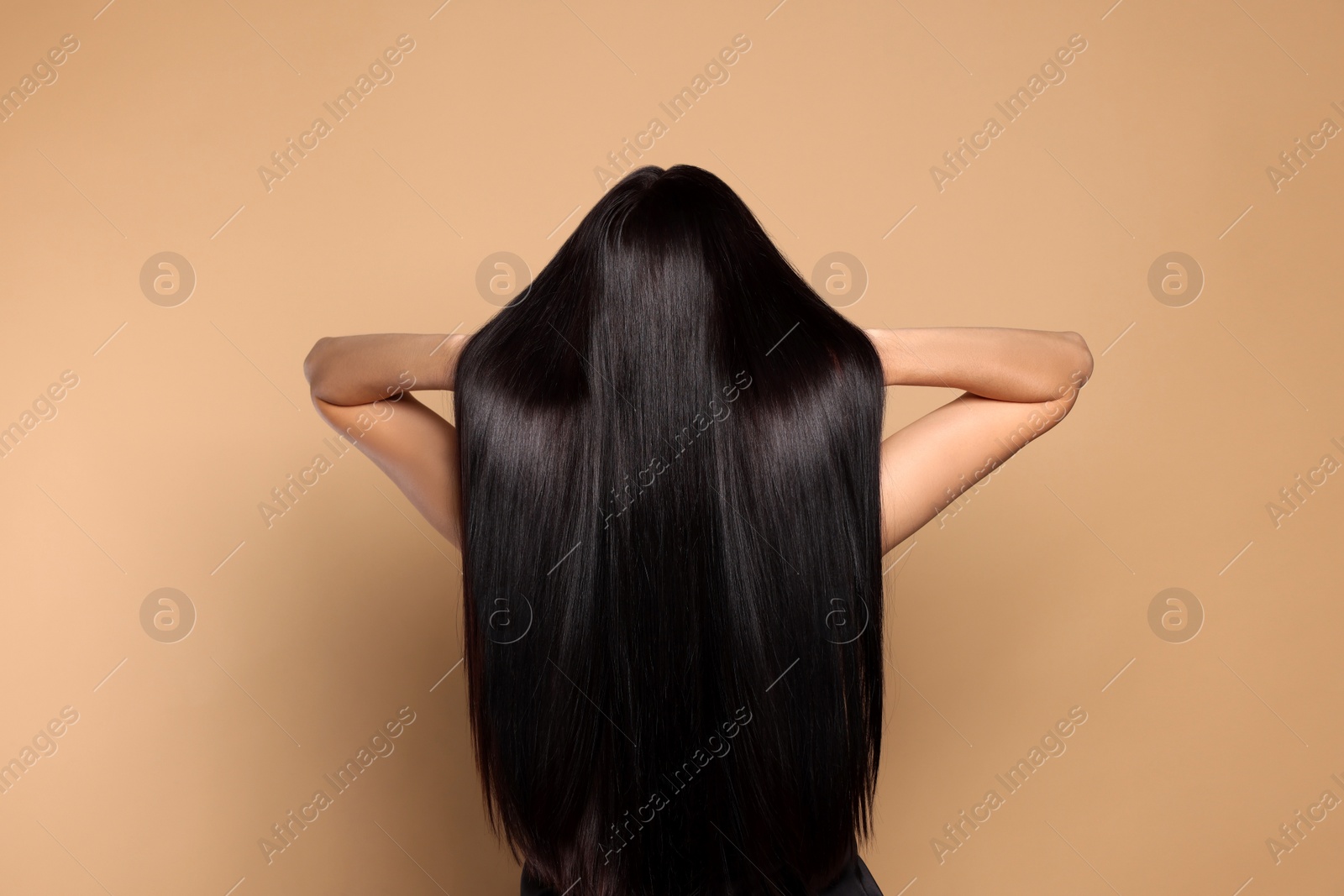 Photo of Woman with strong healthy hair on beige background, back view