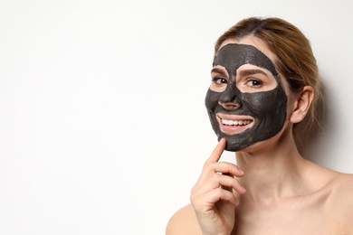 Photo of Beautiful woman with black mask on face against light background. Space for text